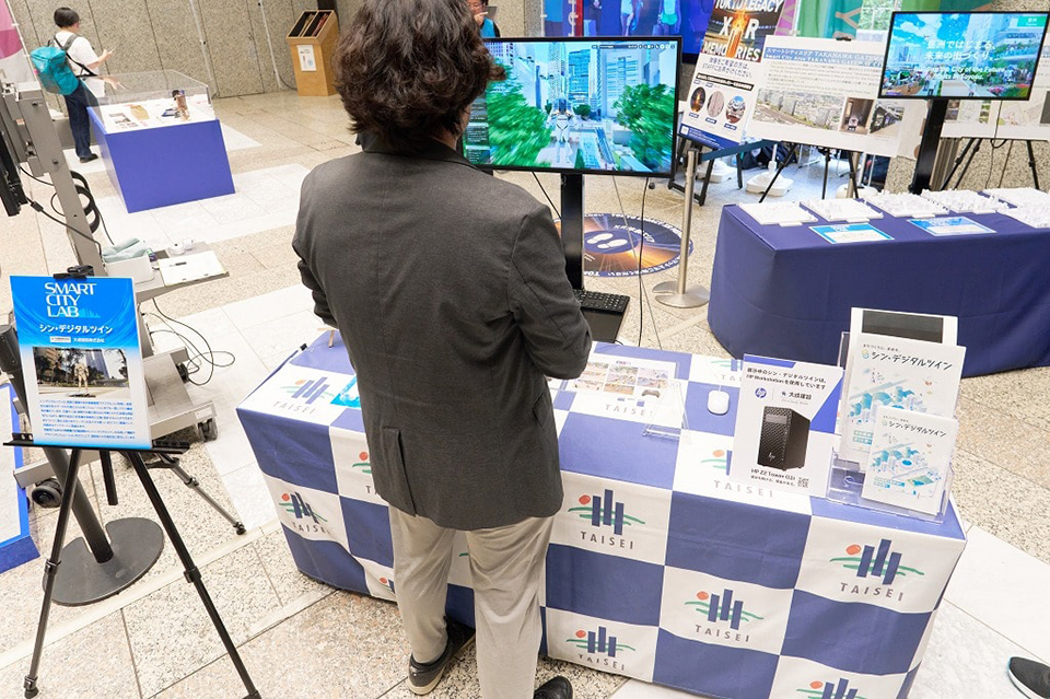 東京都庁で開催された「西新宿スマートシティラボ」。大成建設はシン・デジタルツインが描く未来の西新宿をゲーム感覚で楽しめるデモンストレーションを展示した