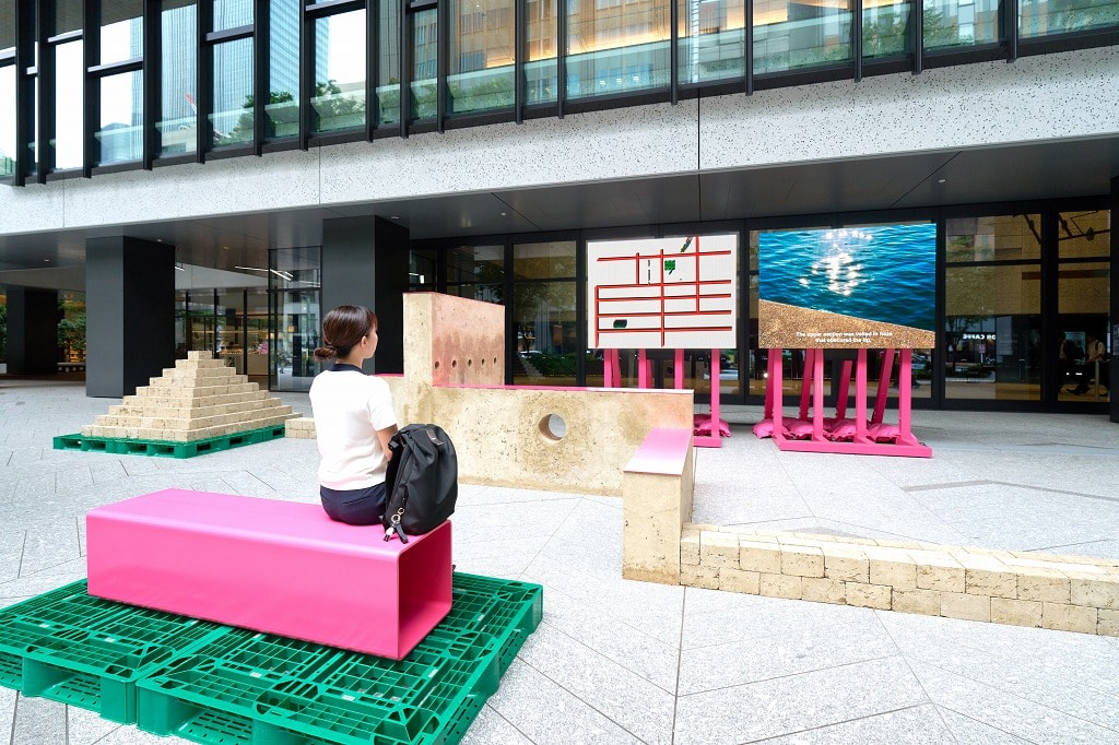 屋外のパブリックスペースに展示された藤倉麻子氏による作品。大きなオブジェクトと大画面モニターに映し出される2つのムービーによってストーリーが表現されている